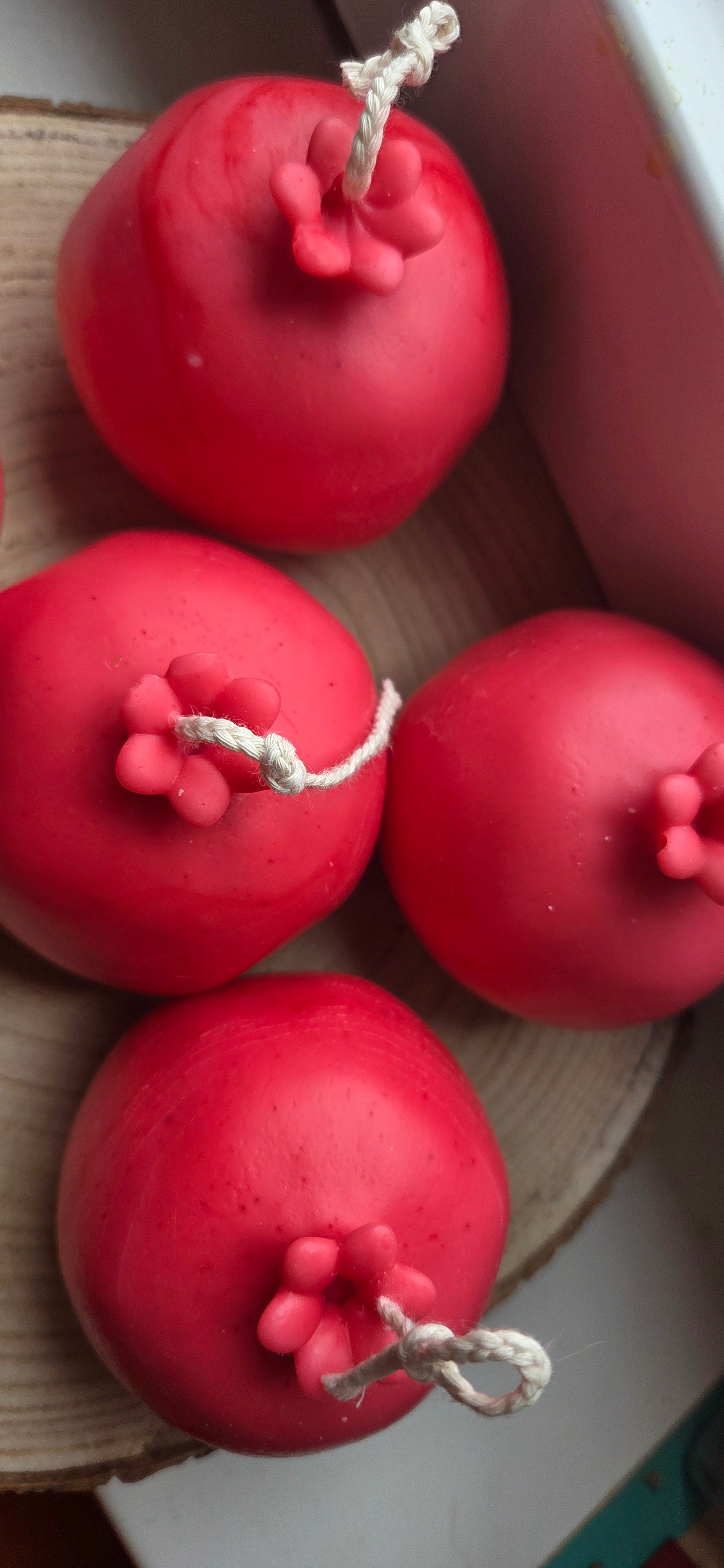 Mehrere Granatapfel-Kerzen auf der Holzplatte